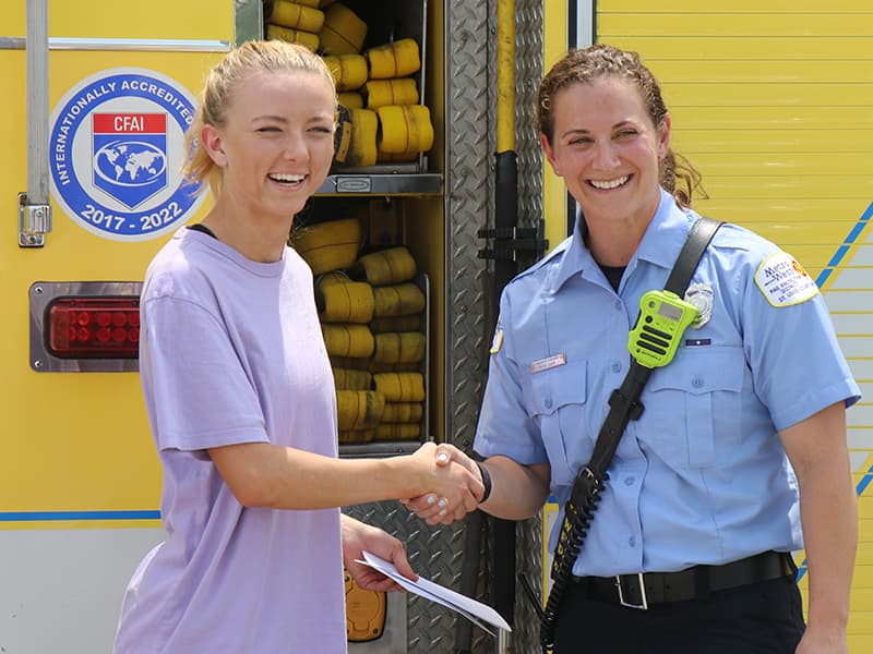 A Lafayette High student shakes hands with a local firefighter