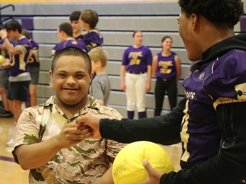 A student congratulates his fellow special-needs student during an athletic event
