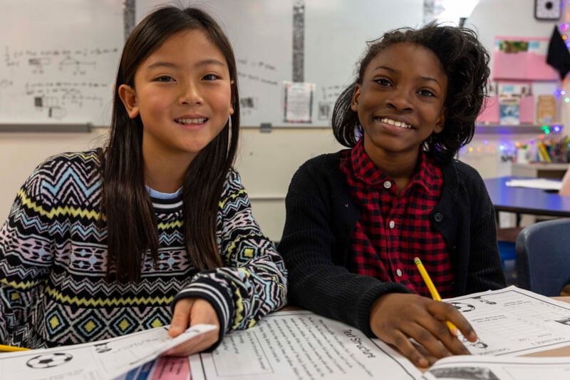 Two Babler students smile while working together in class