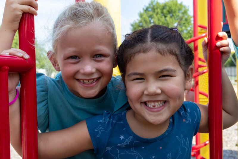 Two Fairway students smile on the school playground