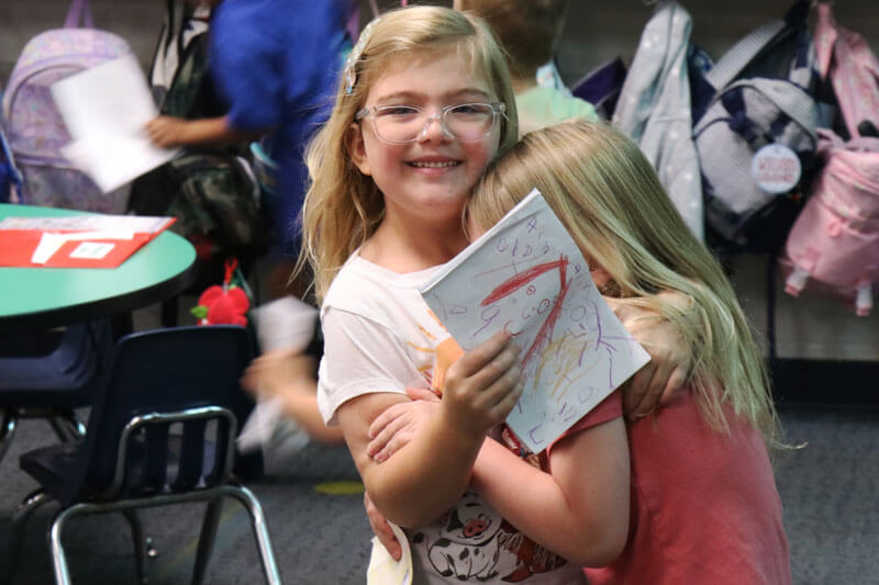 Two Westridge students smile while working together in class